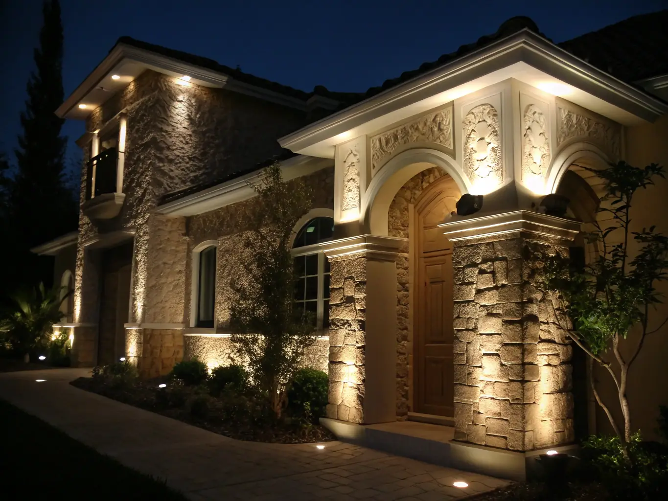 A beautifully lit house at dusk showcasing architectural uplighting that accentuates the building's features, highlighting the home's unique architectural details.